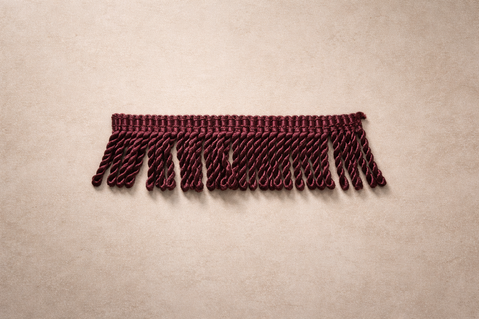 Wild Aubergine fringe tissue box cover featuring dense twisted fringe in a deep red-based aubergine with subtle sheen against a warm neutral background.