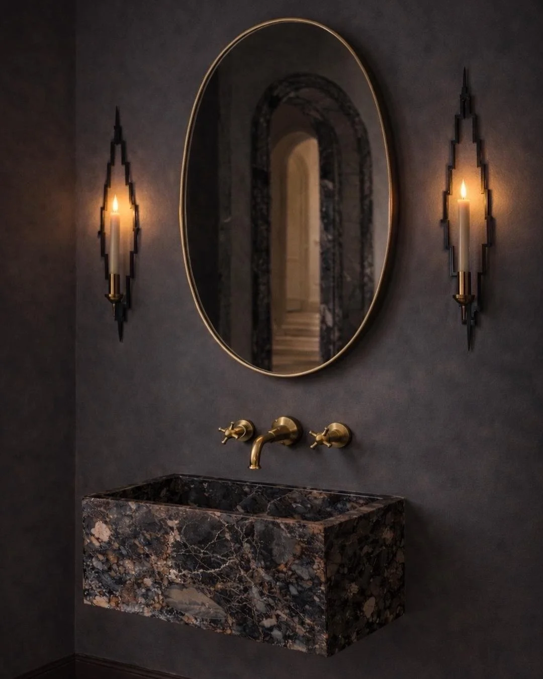 Hand-welded steel vertical wall candle sconce holding a lit taper candle, casting sculptural shadows on a plaster wall