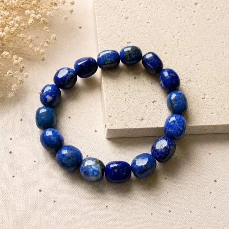 Natural Lapis Lazuli tumble bead bracelet featuring deep blue gemstone beads with natural gold pyrite flecks on stretch elastic.