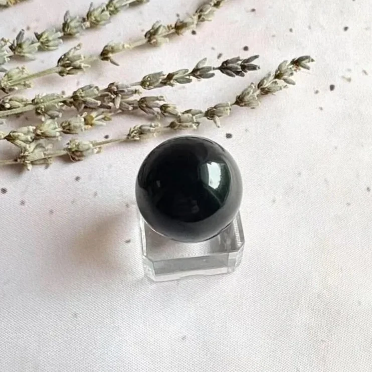 Polished Black Obsidian crystal sphere with a glossy black finish