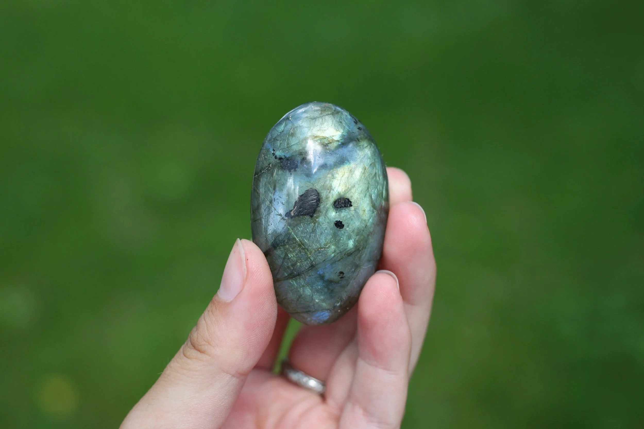 Labradorite palm stone displaying blue flash, traditionally associated with the Third Eye Chakra