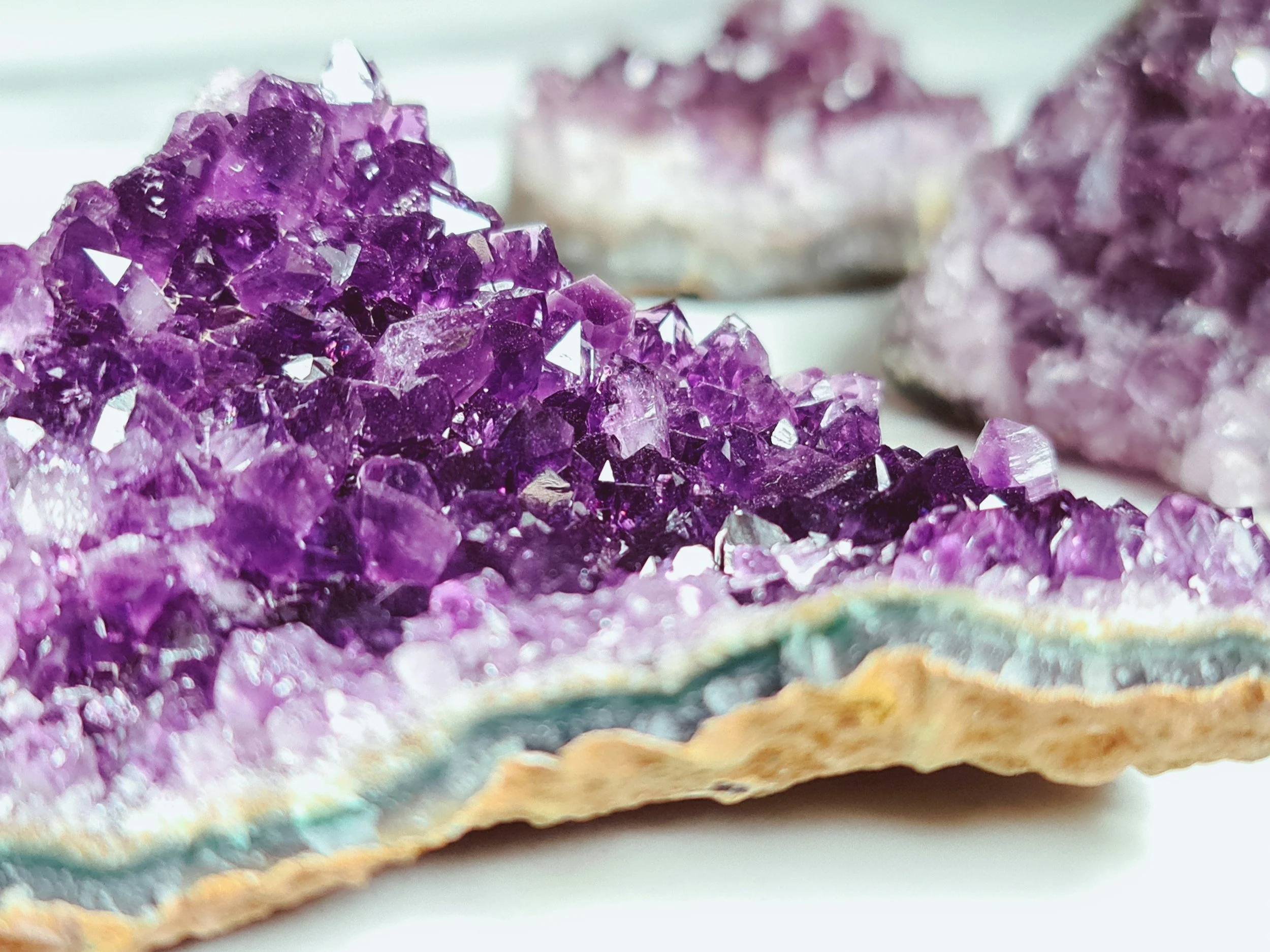 Amethyst crystals on a mineral slab, traditionally associated with the Crown Chakra