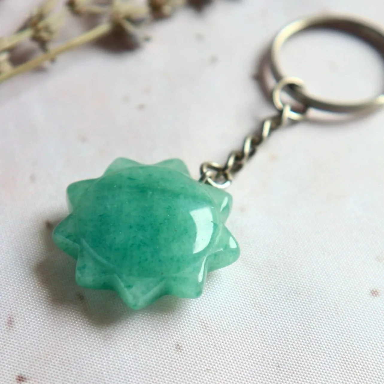 Close-up of a green starburst gemstone keyring showing its pointed edges.