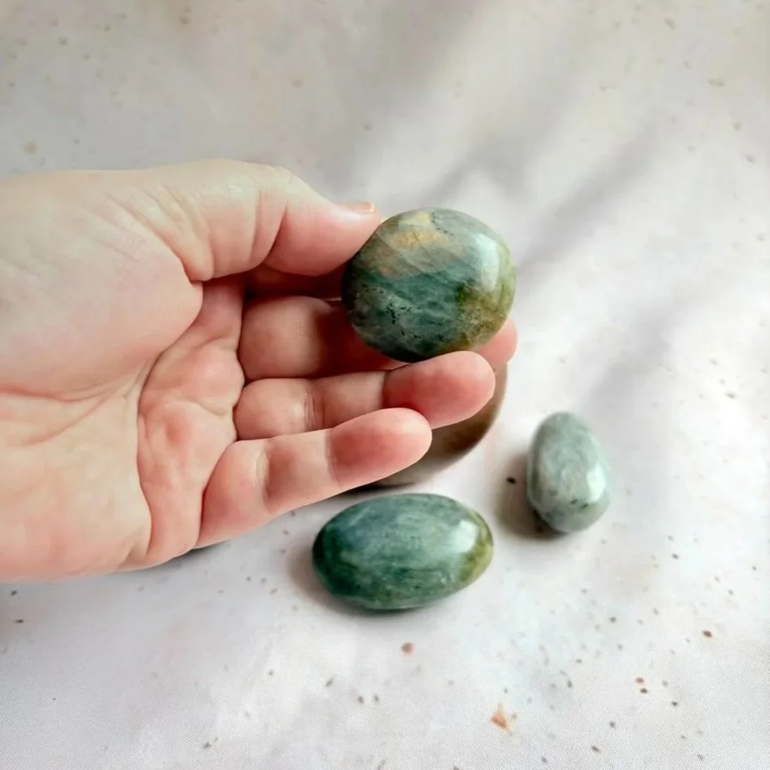 Polished Labradorite palm stone displaying natural blue and gold flash