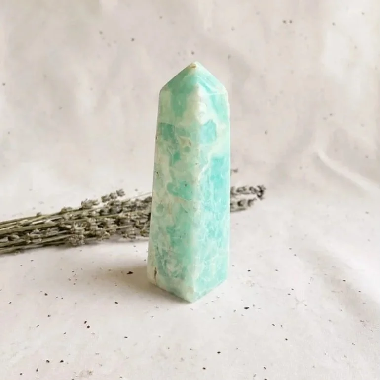 Polished Caribbean Calcite crystal tower displaying soft blue, cream, and sandy natural banding