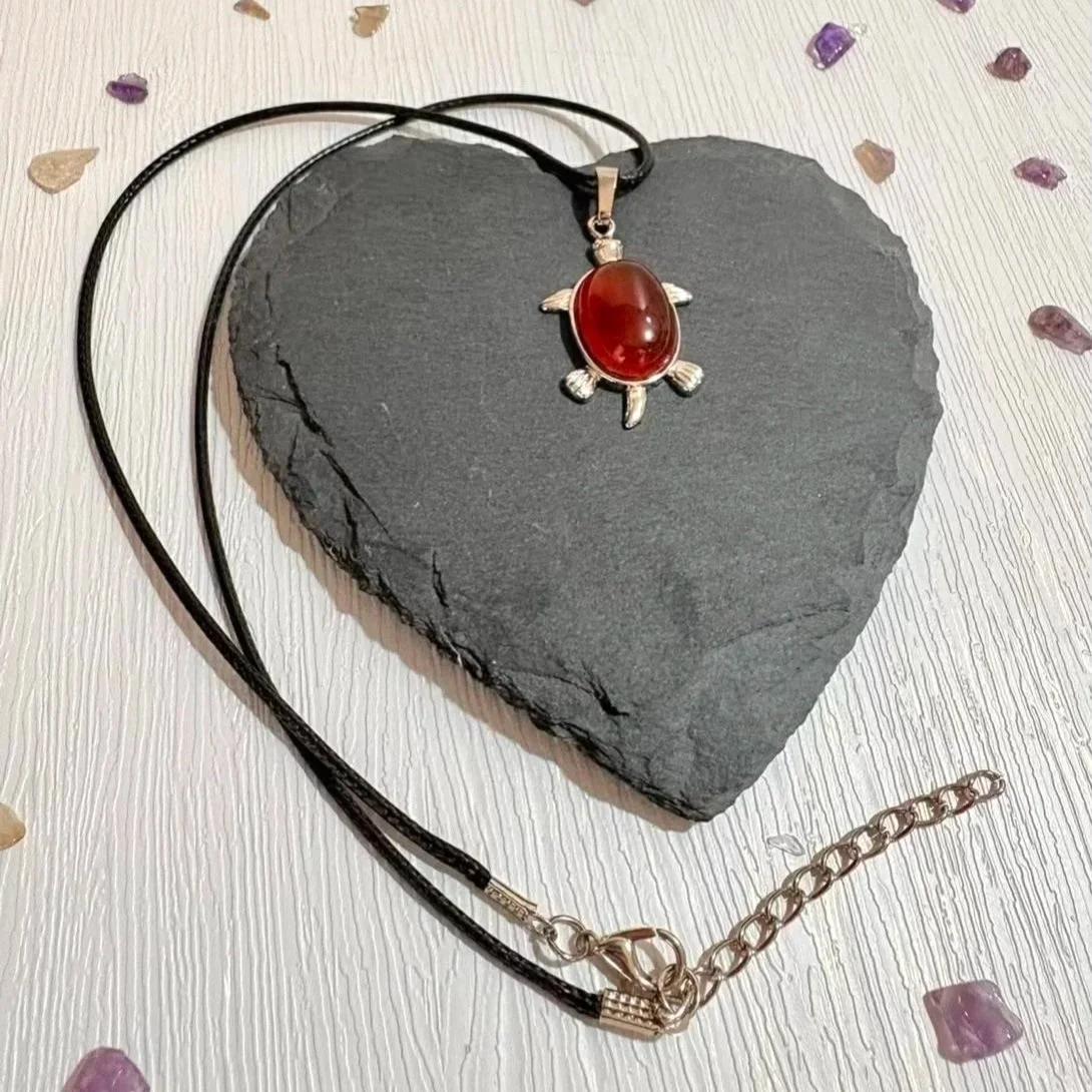 Carnelain crystal turtle pendant showing warm orange tones
