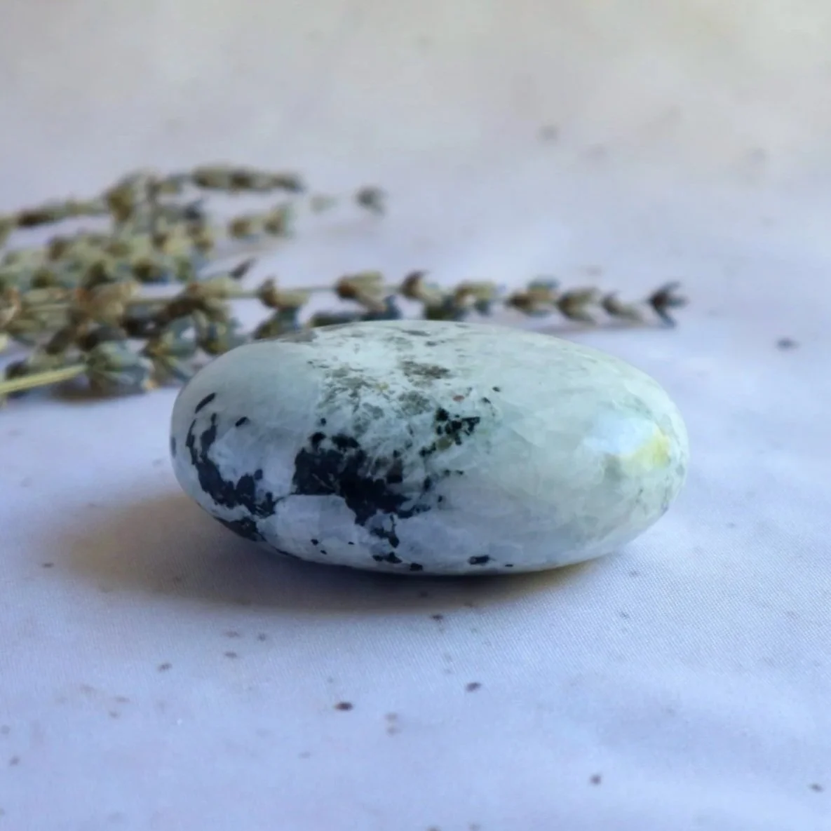 Polished Rainbow Moonstone palm stone weighing approximately 106 g