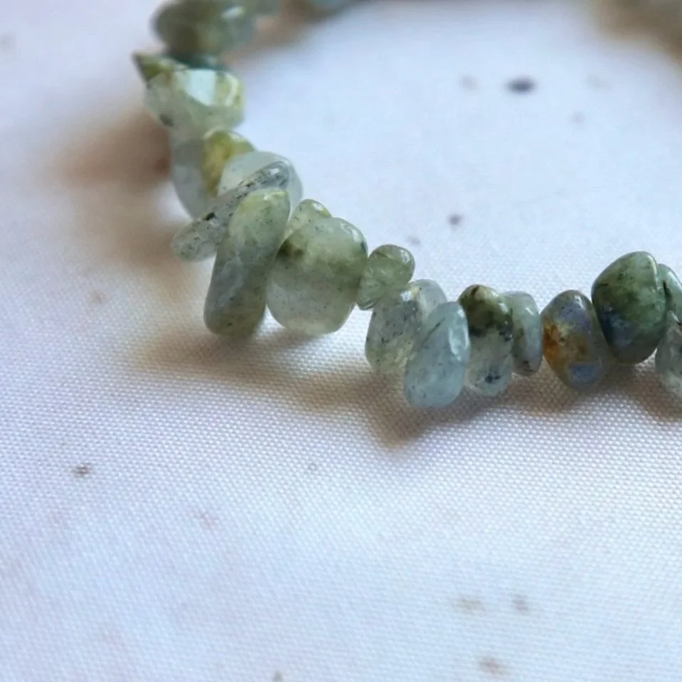 Close-up of natural grey Labradorite chips with blue and green colour flashes.