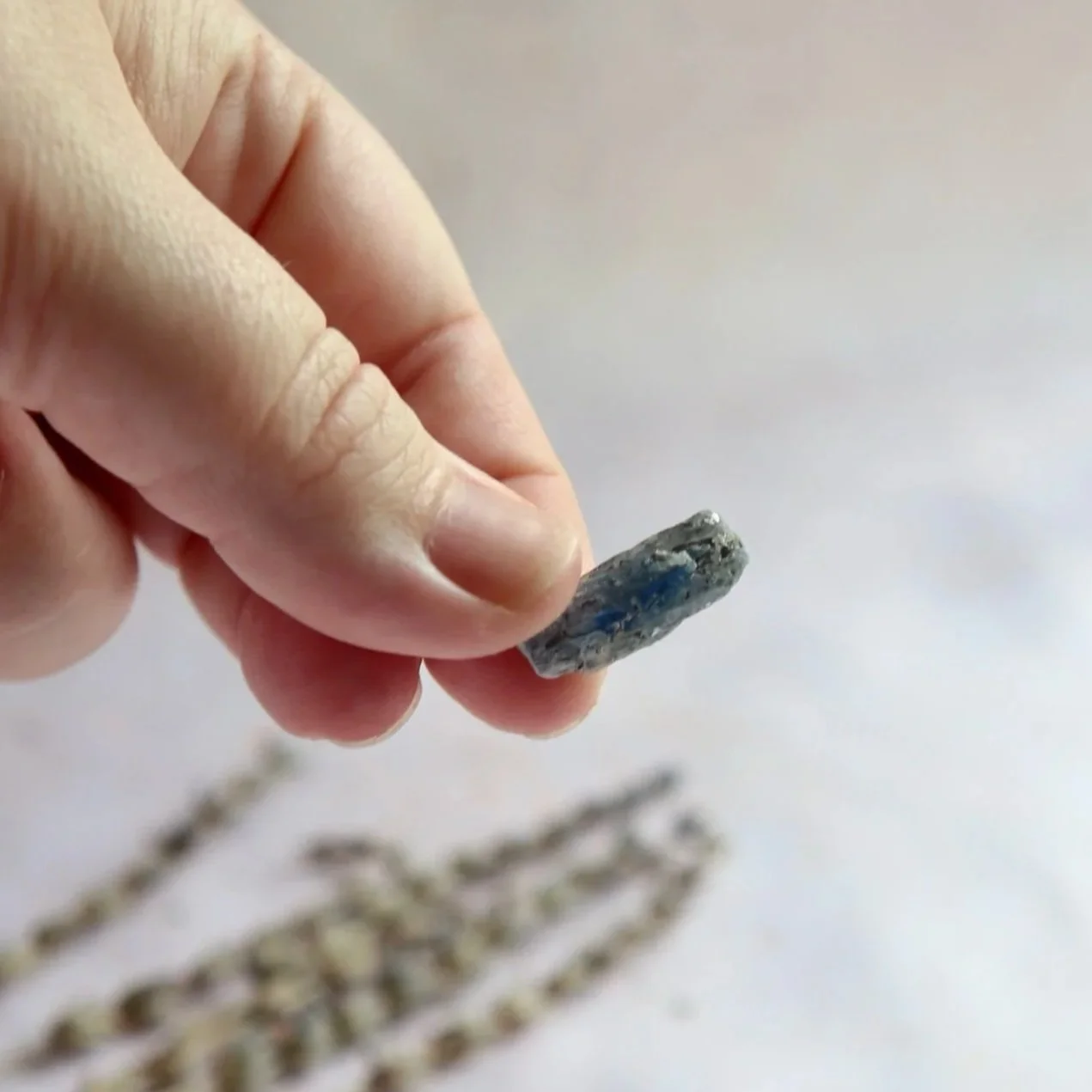 Single Blue Kyanite mineral specimen being held for scale