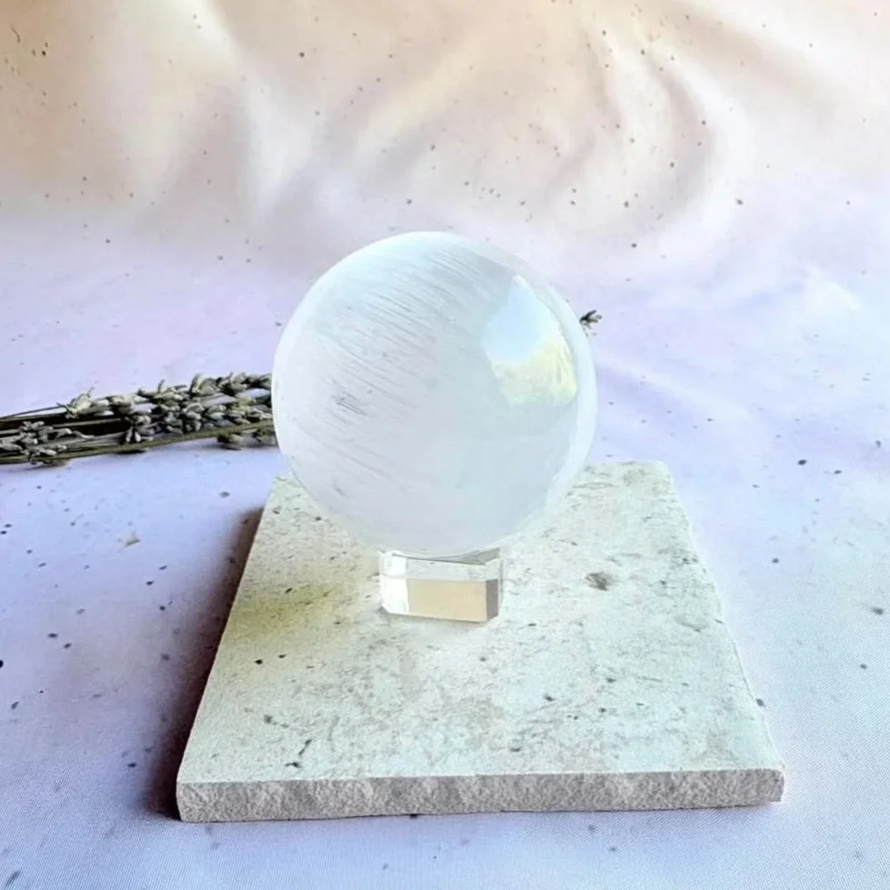 Satin Spar sphere displaying natural fibrous patterns and a polished finish