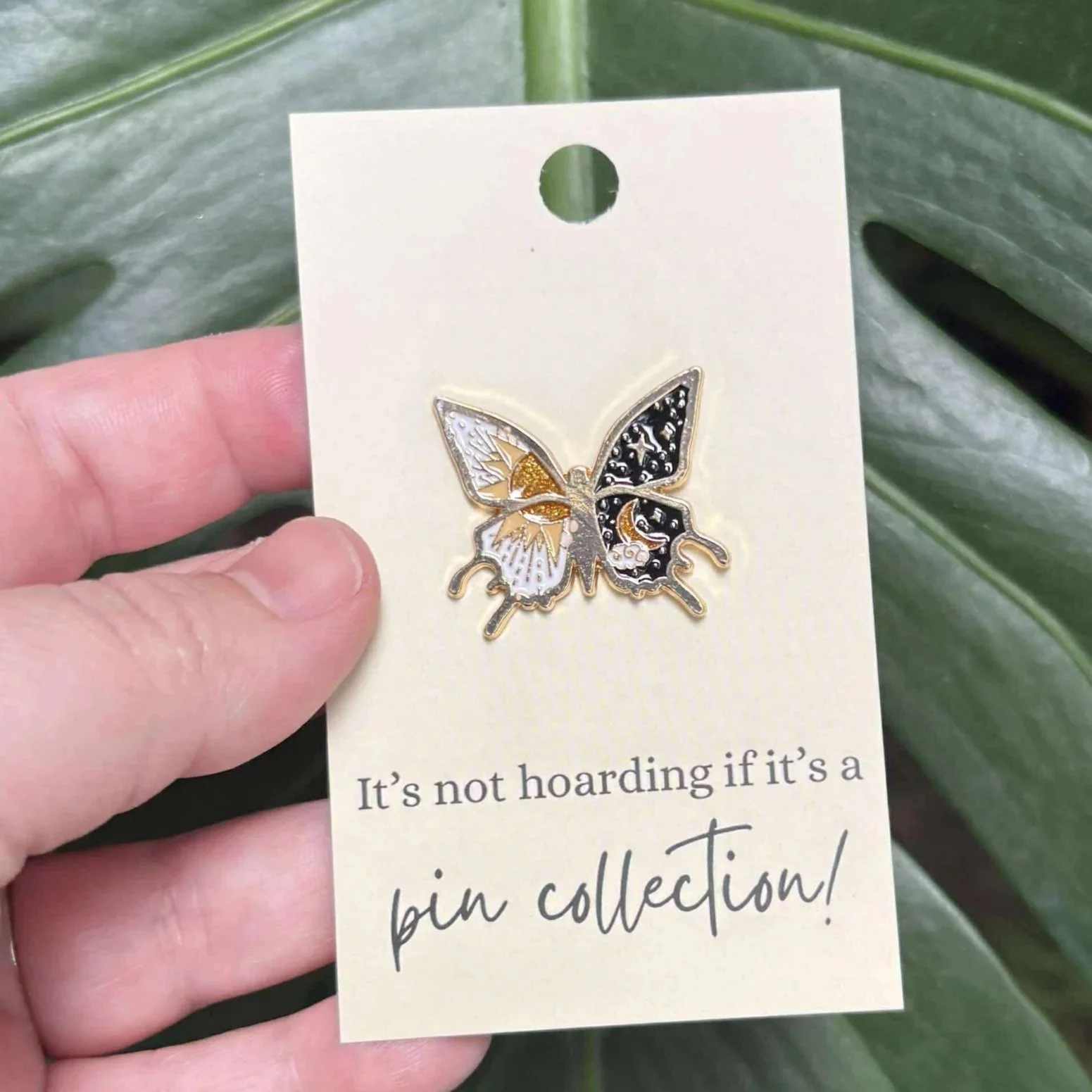 Celestial butterfly enamel pin featuring day and night wing designs.