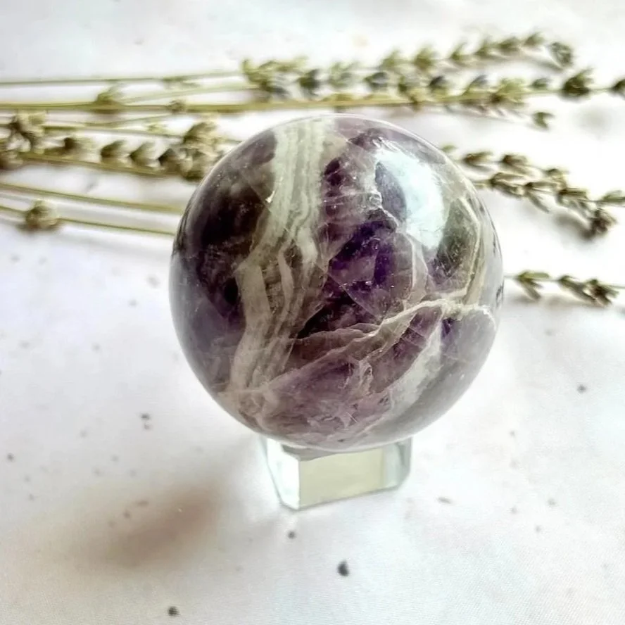 Natural Chevron Amethyst crystal sphere displaying purple and white banding