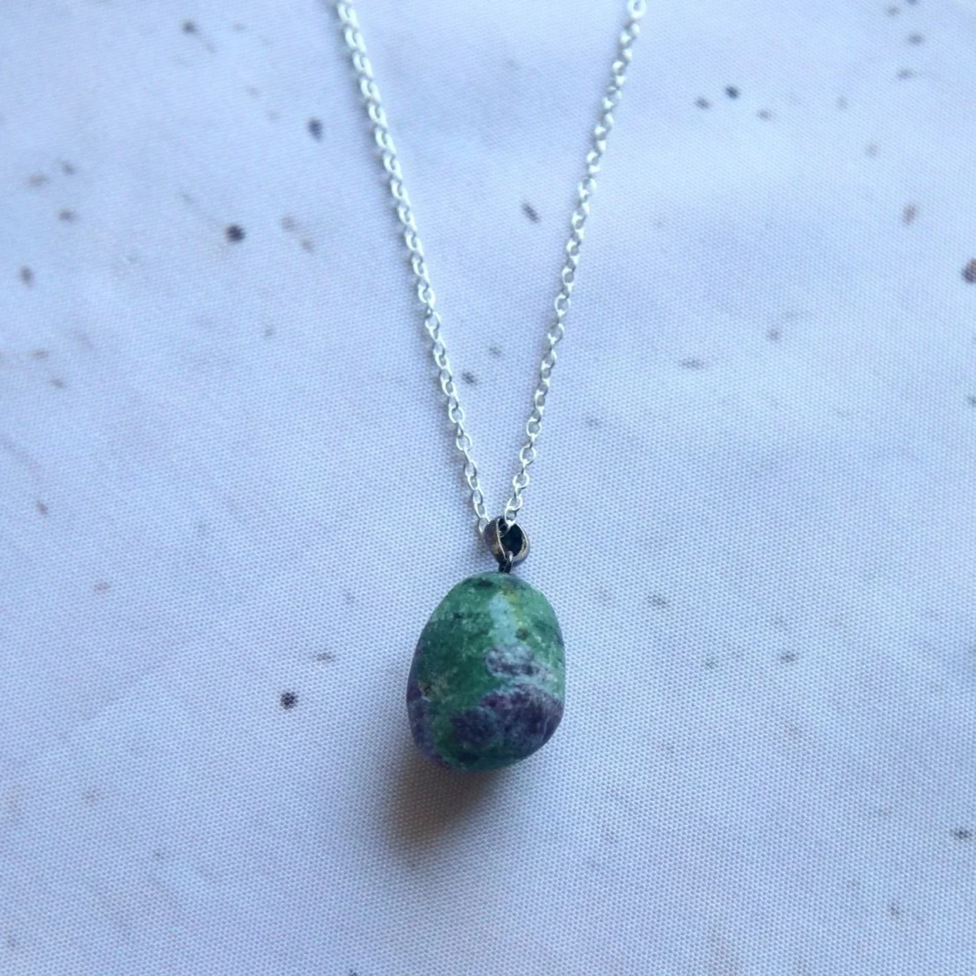 Ruby Zoisite gemstone necklace with an irregular egg-shaped pendant featuring green and ruby-red colouring on a sterling silver chain.