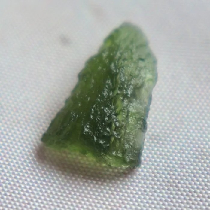 Close-up of a small Czech Republic Moldavite impact glass specimen.