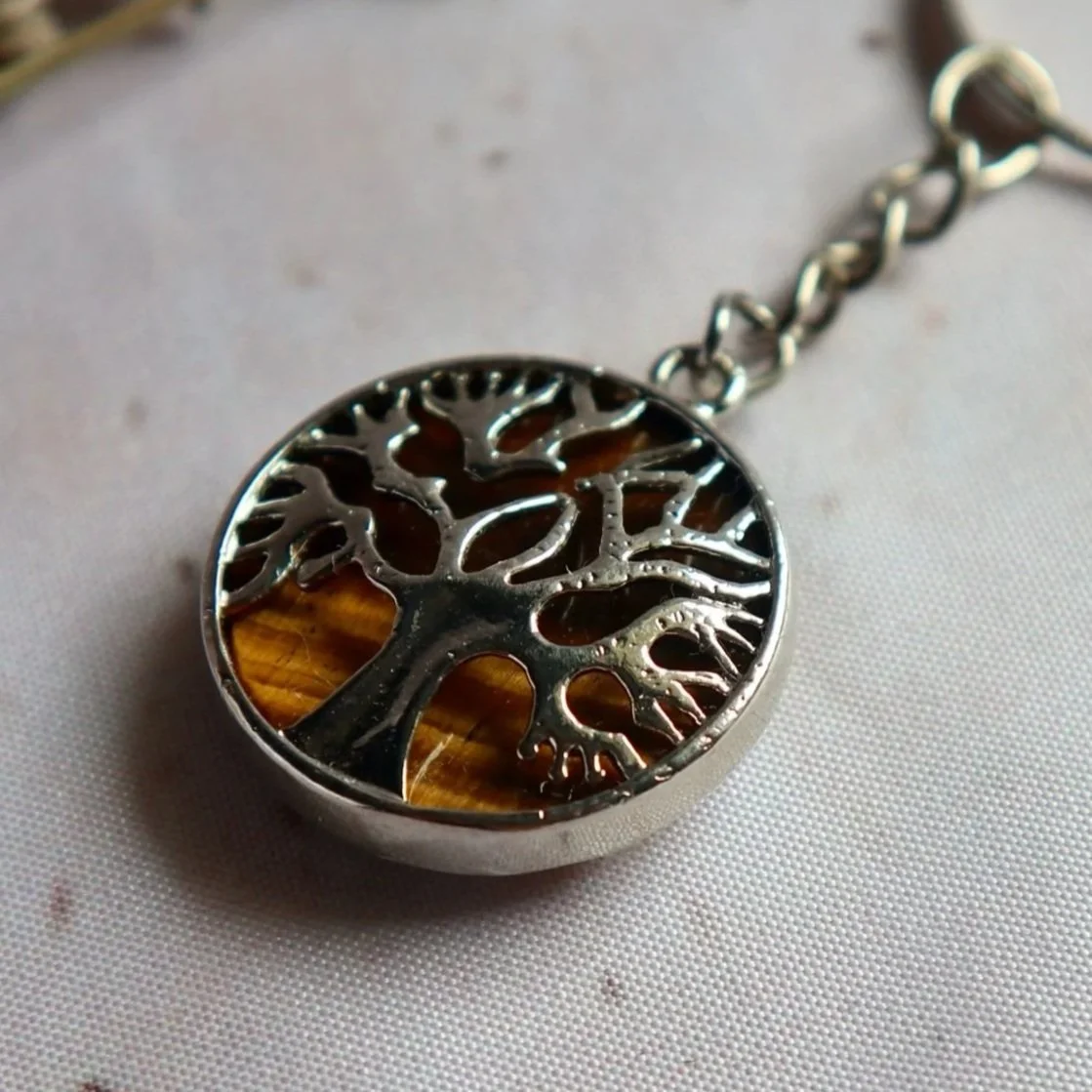 Close-up of a Tree of Life gemstone keyring with a polished Tiger's Eye stone and silver-tone bail.