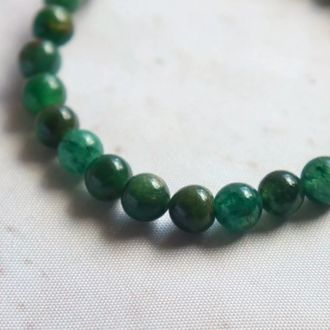 Close-up of a Fuchsite bracelet showing the green colour of its polished mineral beads.