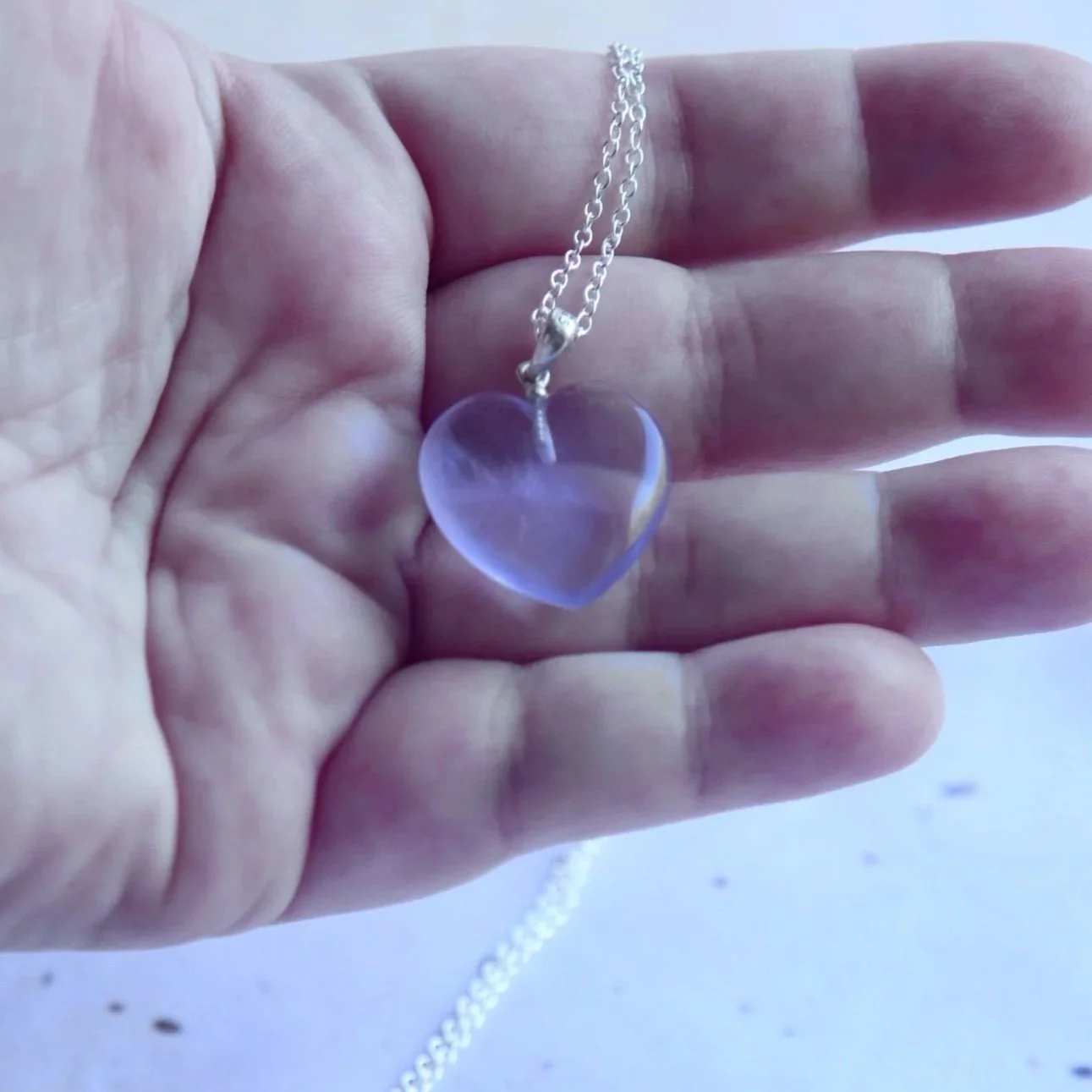 Close-up of natural lavender and purple colouring in a Fluorite heart necklace
