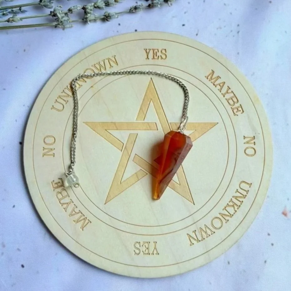 Natural Carnelian dowsing pendulum displaying vibrant orange and red tones