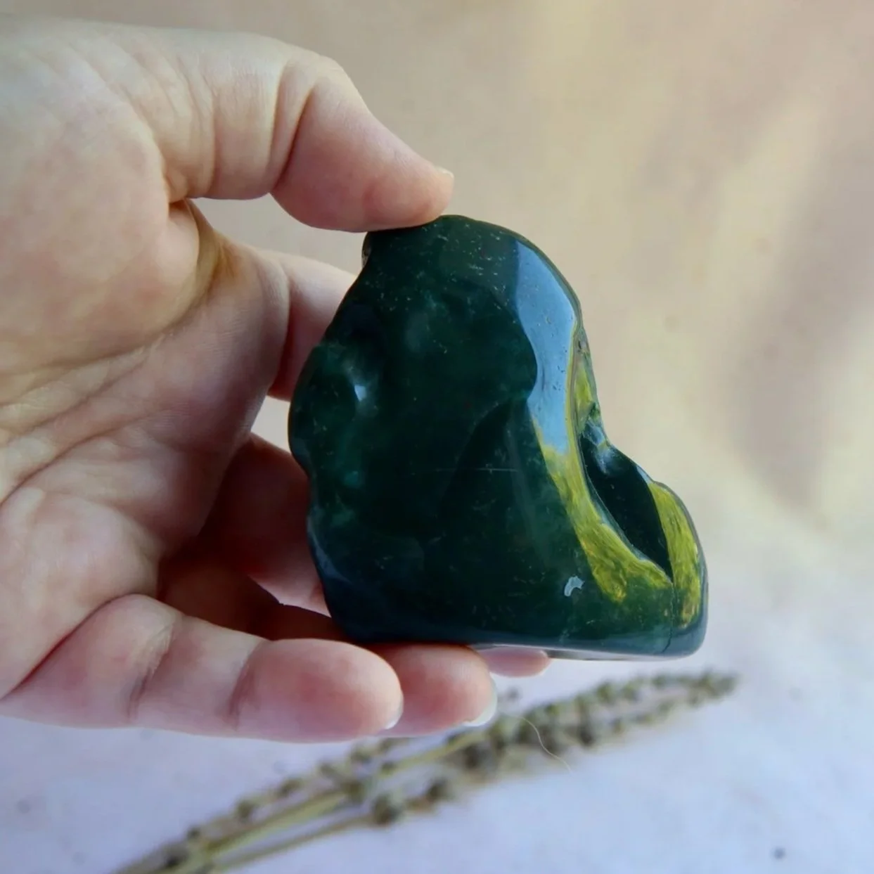 Bloodstone crystal freeform held in hand for size reference