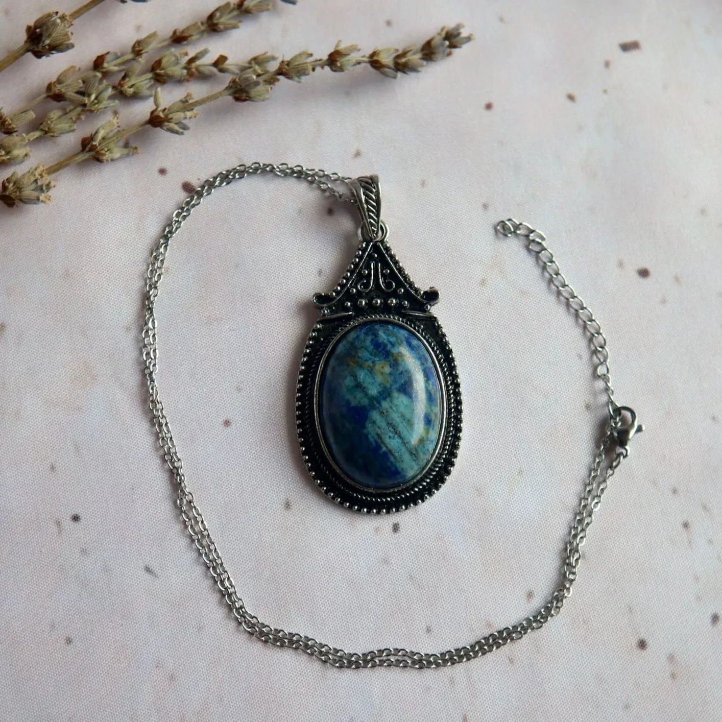 Lapis Lazuli gemstone necklace featuring a polished oval stone in an antique silver-toned setting