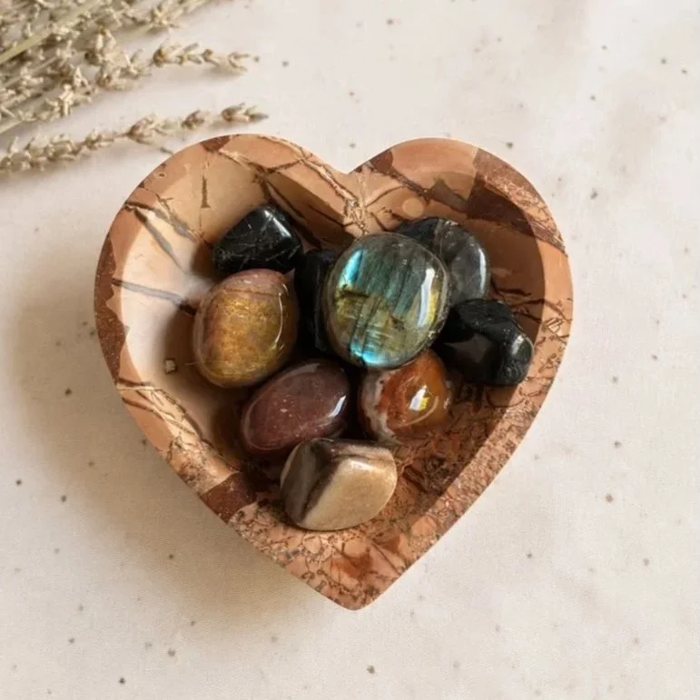Red Picture Jasper crystal bowl holding assorted crystal tumbles for display and storage.