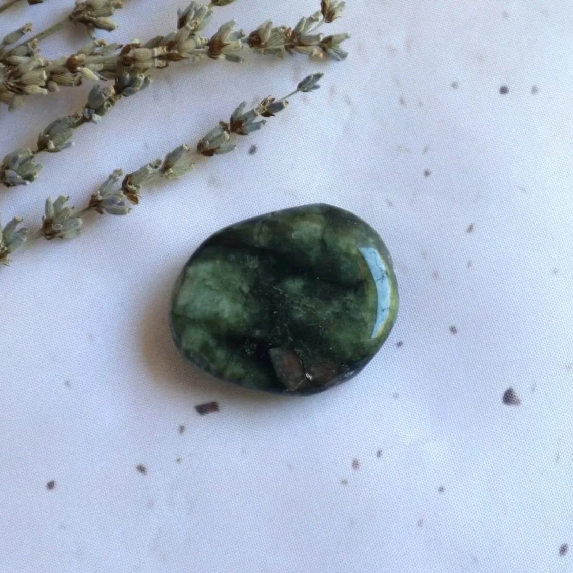 Natural Emerald flat stone held in hand for approximate size reference