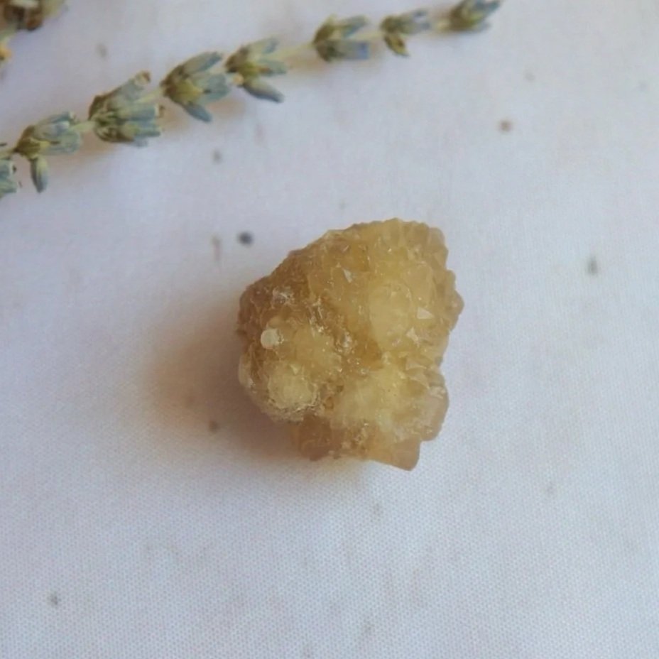 Natural golden-yellow Citrine crystal specimen on a white surface