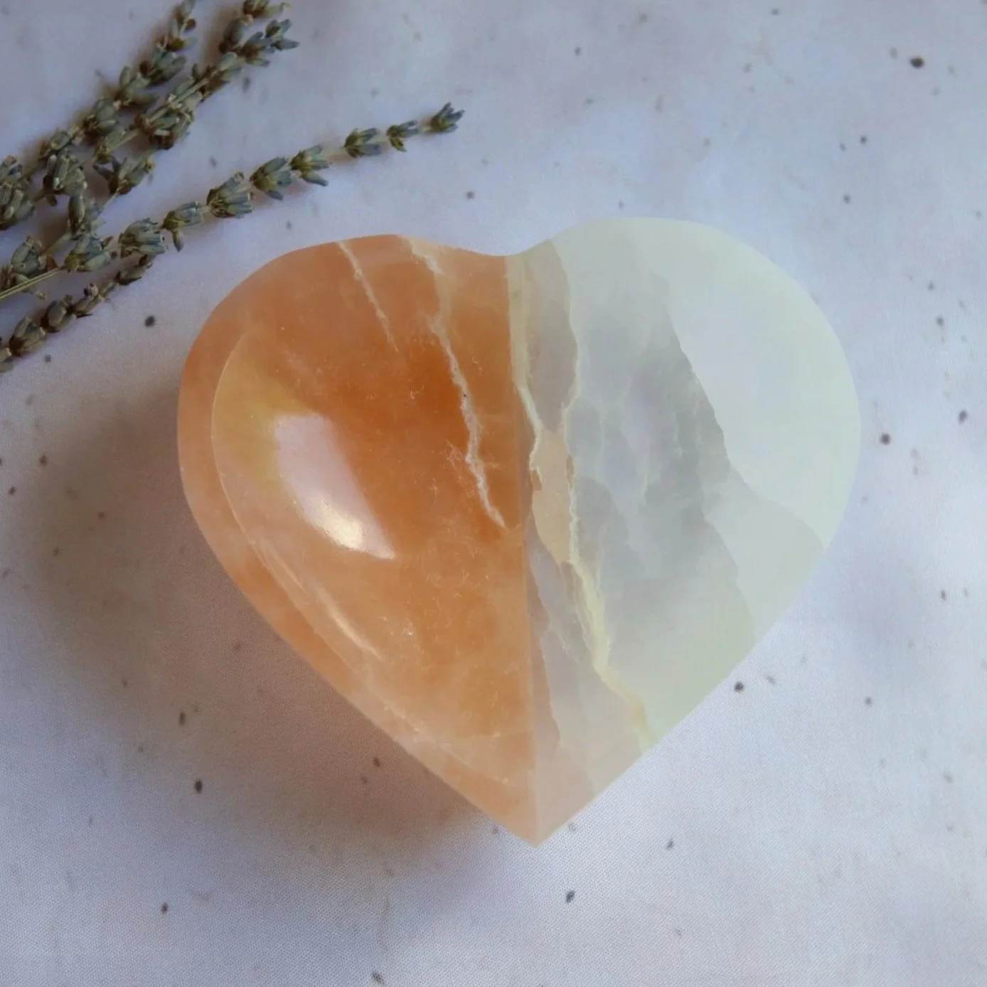 Two-tone Satin Spar heart-shaped bowl featuring contrasting peach and white sections