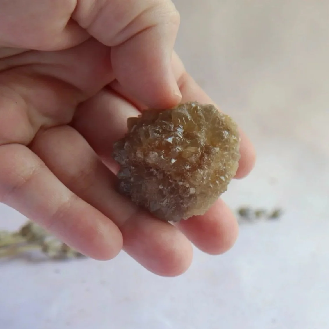 Golden natural Citrine rough specimen held in hand showing its natural uneven texture