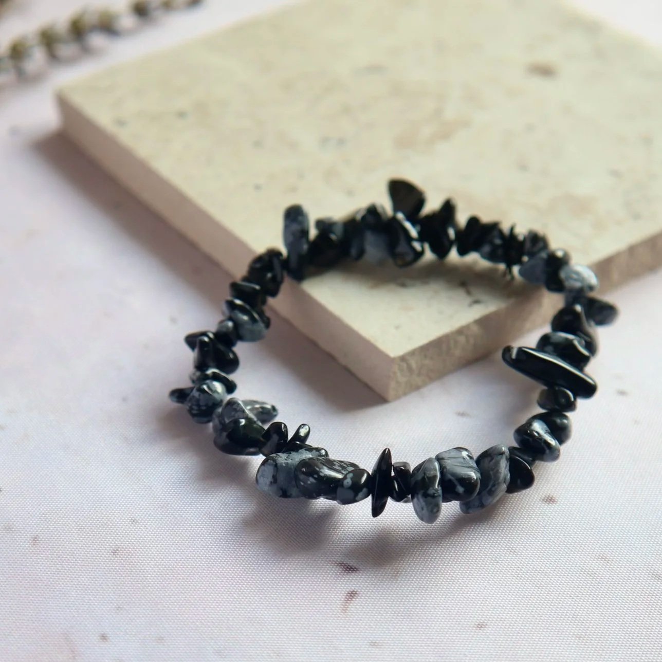 Snowflake Obsidian bracelet displaying distinctive pale cristobalite inclusions against deep black volcanic glass