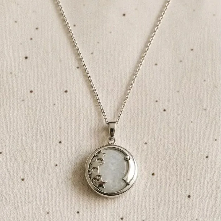 Clear Quartz pendant necklace featuring a silver-toned moon and stars design on a stainless steel chain