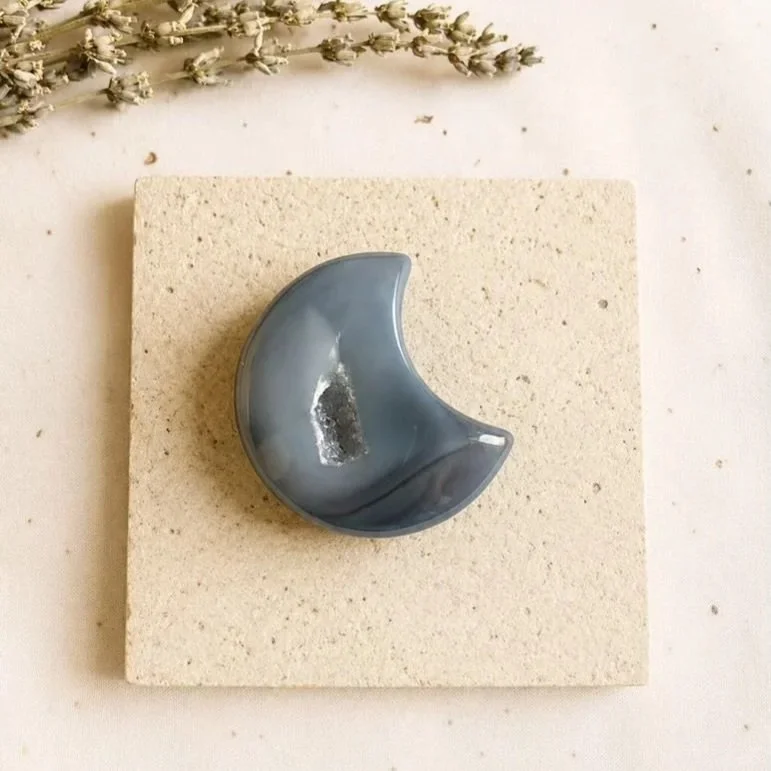 Natural Agate moon carving displaying banded patterns and a sparkling druzy crystal feature