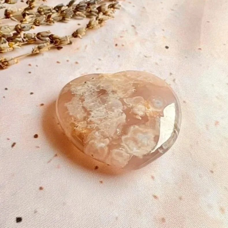 Polished Flower Agate crystal heart displaying soft pink and cream tones