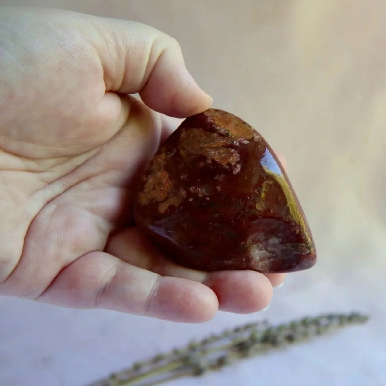 Bloodstone crystal freeform held in hand for size reference
