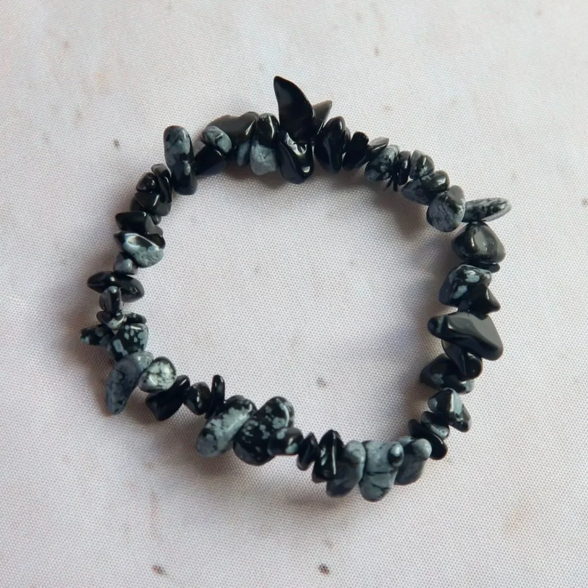 Snowflake Obsidian chip bead bracelet featuring black volcanic glass with natural pale snowflake-like markings