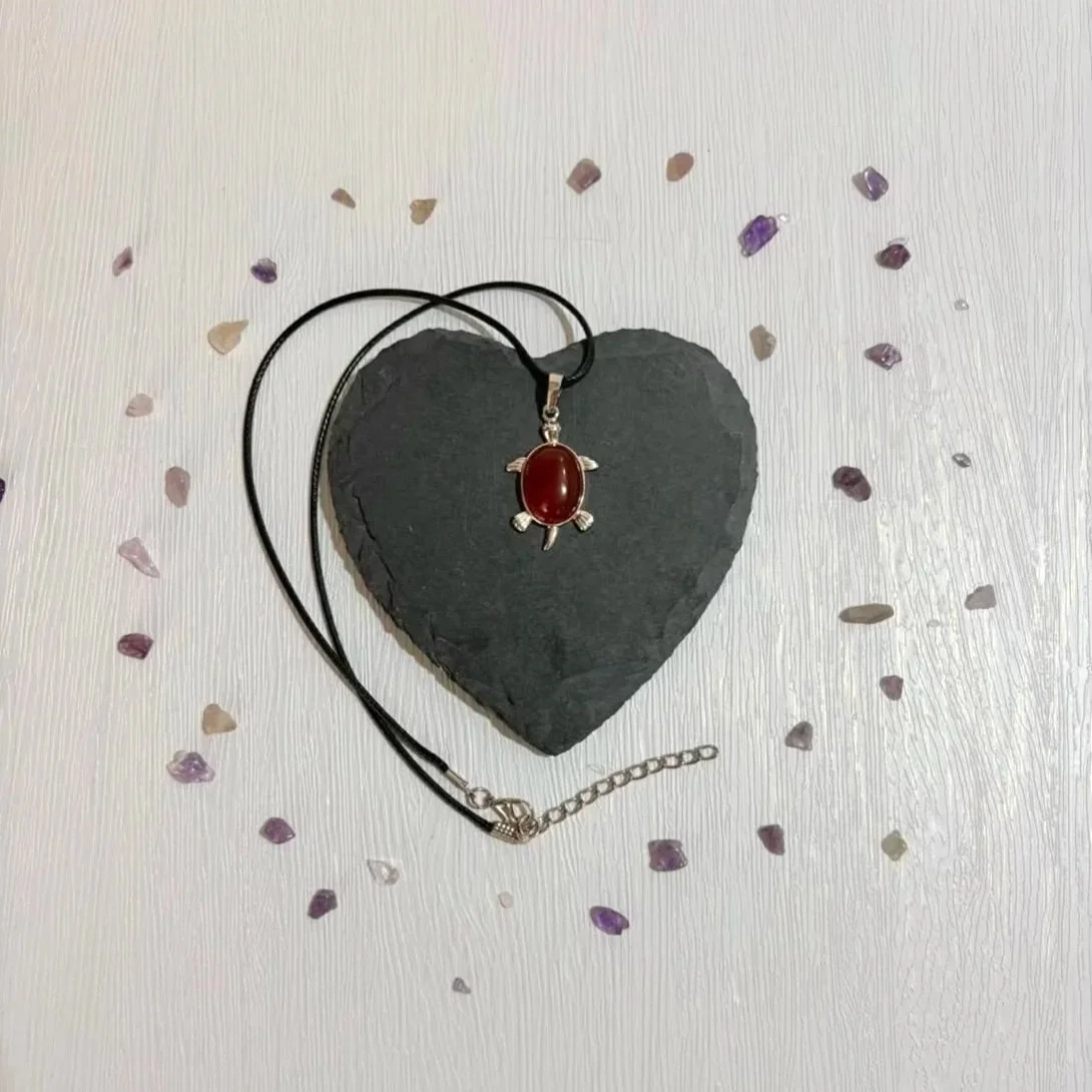 Crystal turtle pendant necklace displayed on natural background