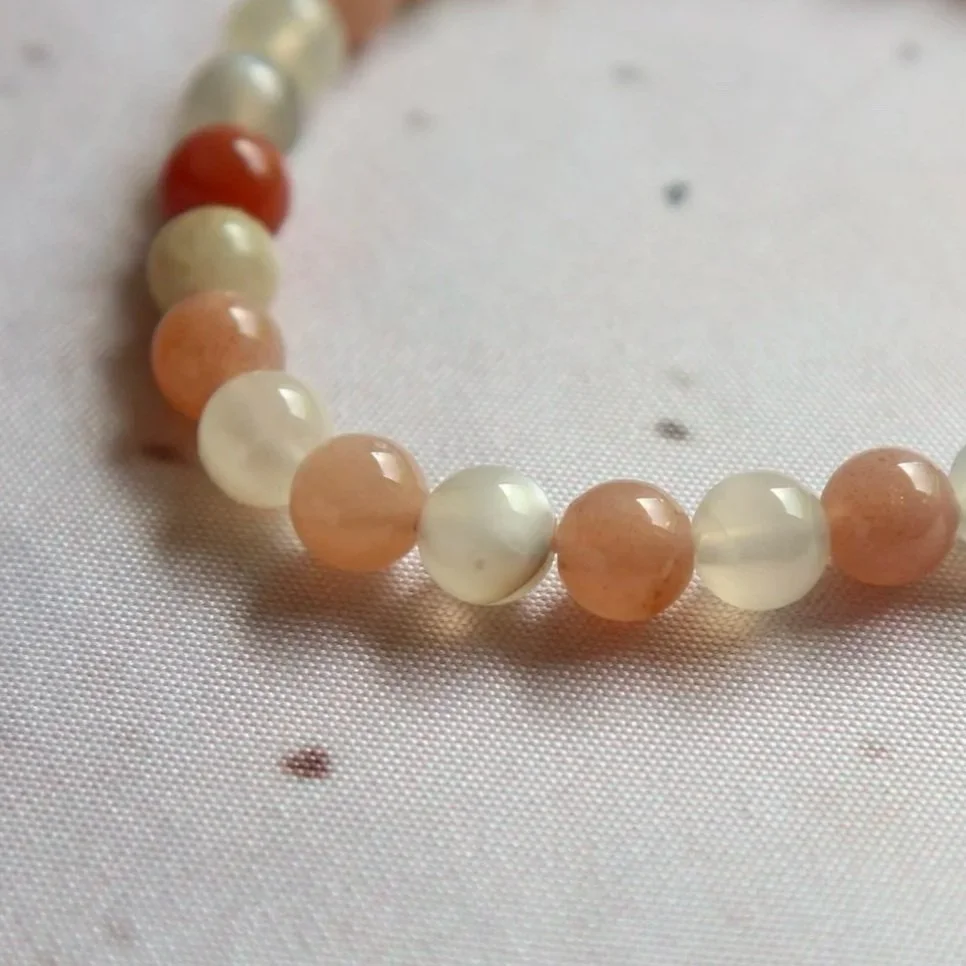 Close-up of polished mixed Moonstone beads on a crystal bracelet.