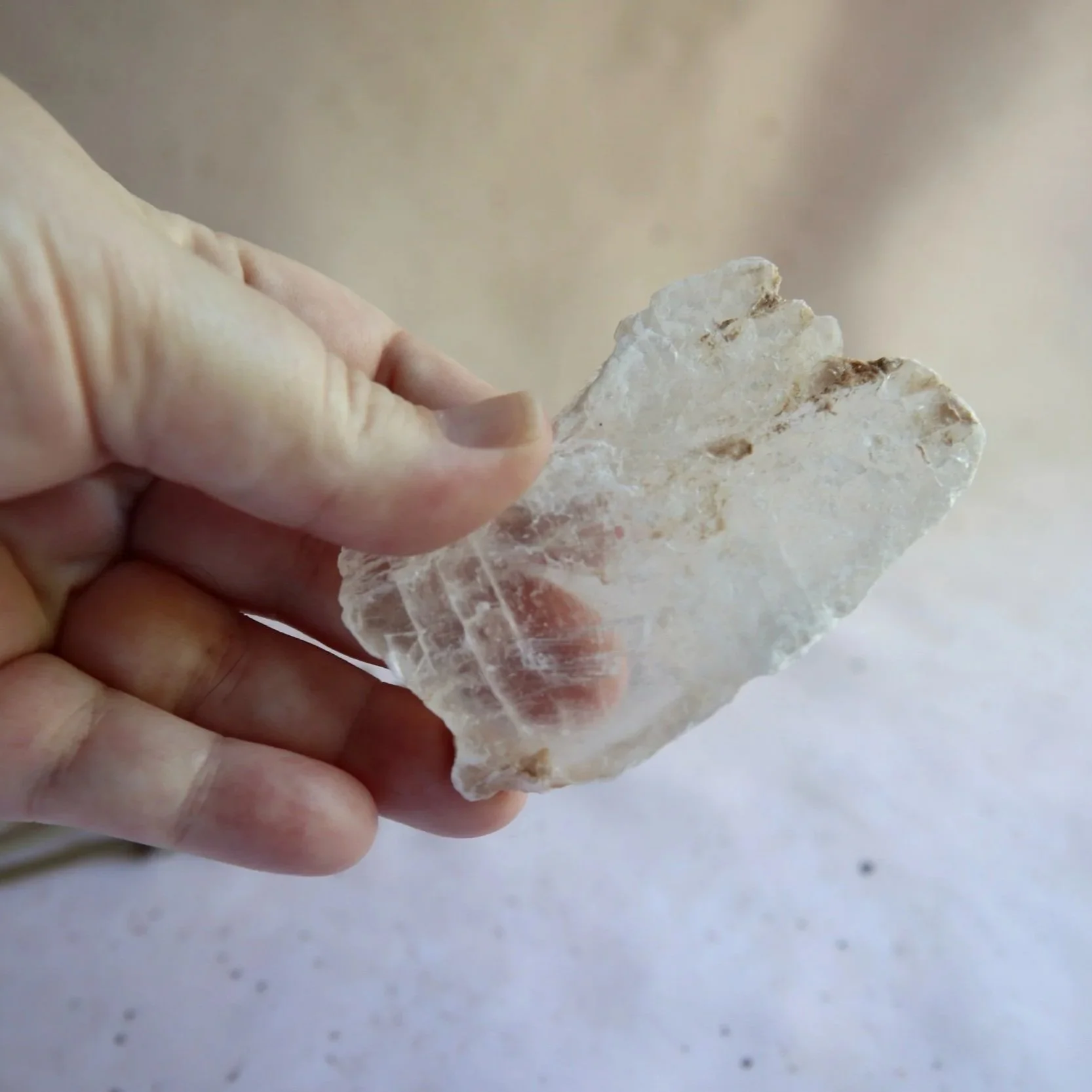 Selenite crystal held in hand for size reference
