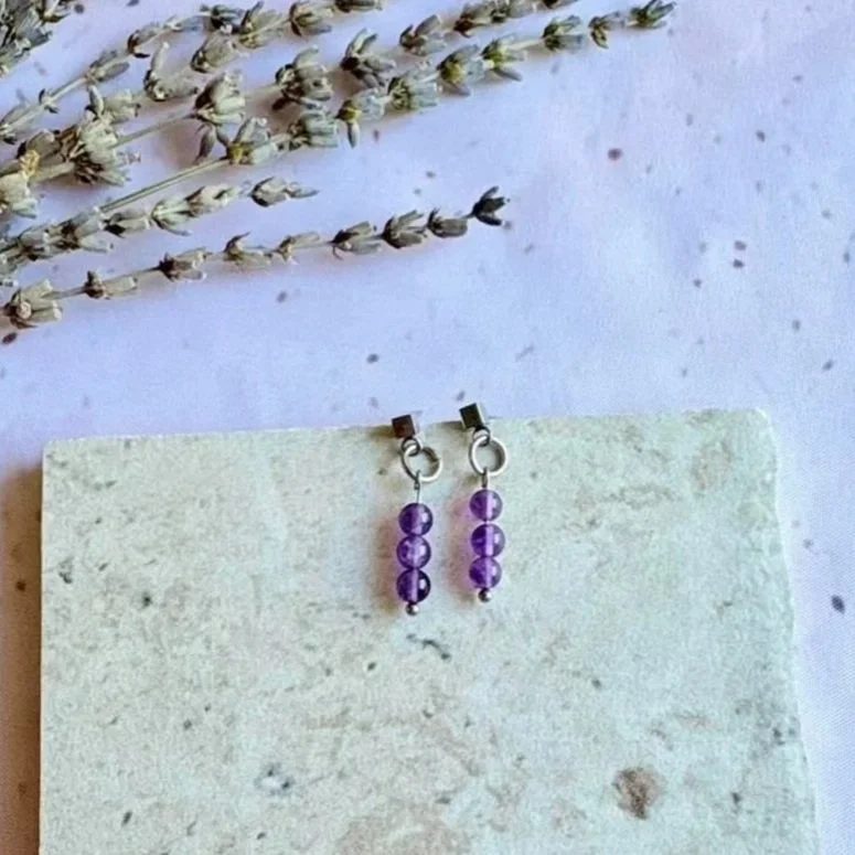Handmade crystal earrings featuring three polished Amethyst beads