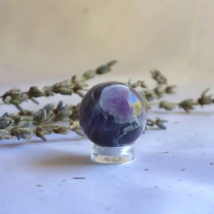 Chevron Amethyst crystal sphere with purple and white patterns