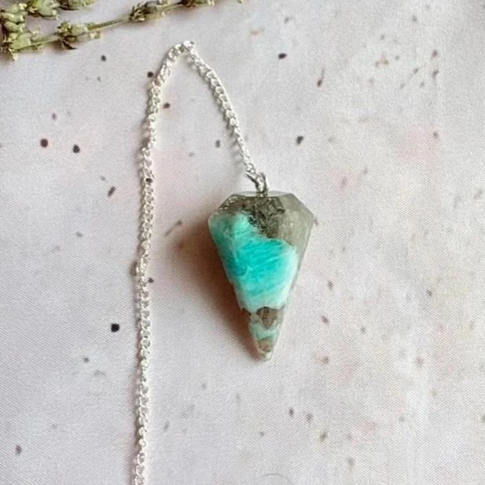 Amazonite pendulum featuring a polished crystal point