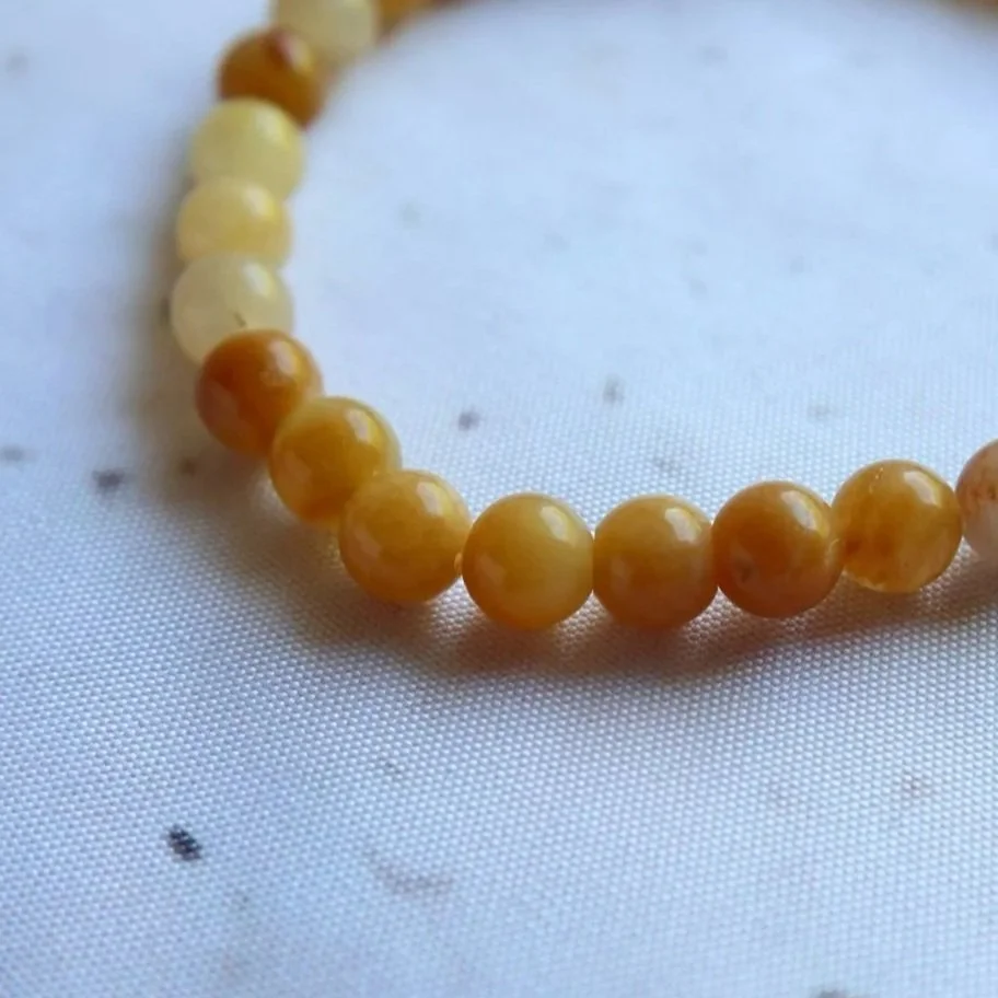 Close-up of golden tones and natural inclusions in a Golden Healer bead bracelet