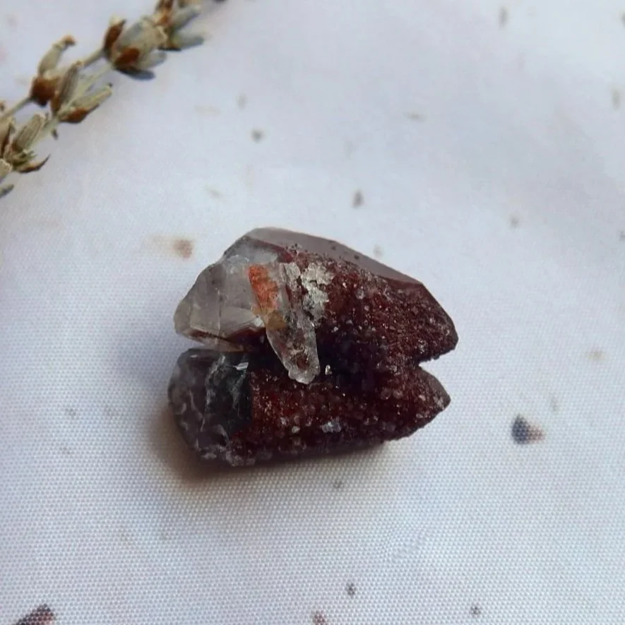 Exact Hematite in Quartz specimen photographed from above, showing its burgundy-red mineral surface and lighter Quartz crystals.