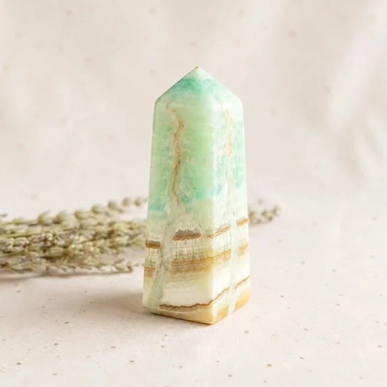 Caribbean Calcite crystal tower with natural blue and brown patterns, polished into a standing point.