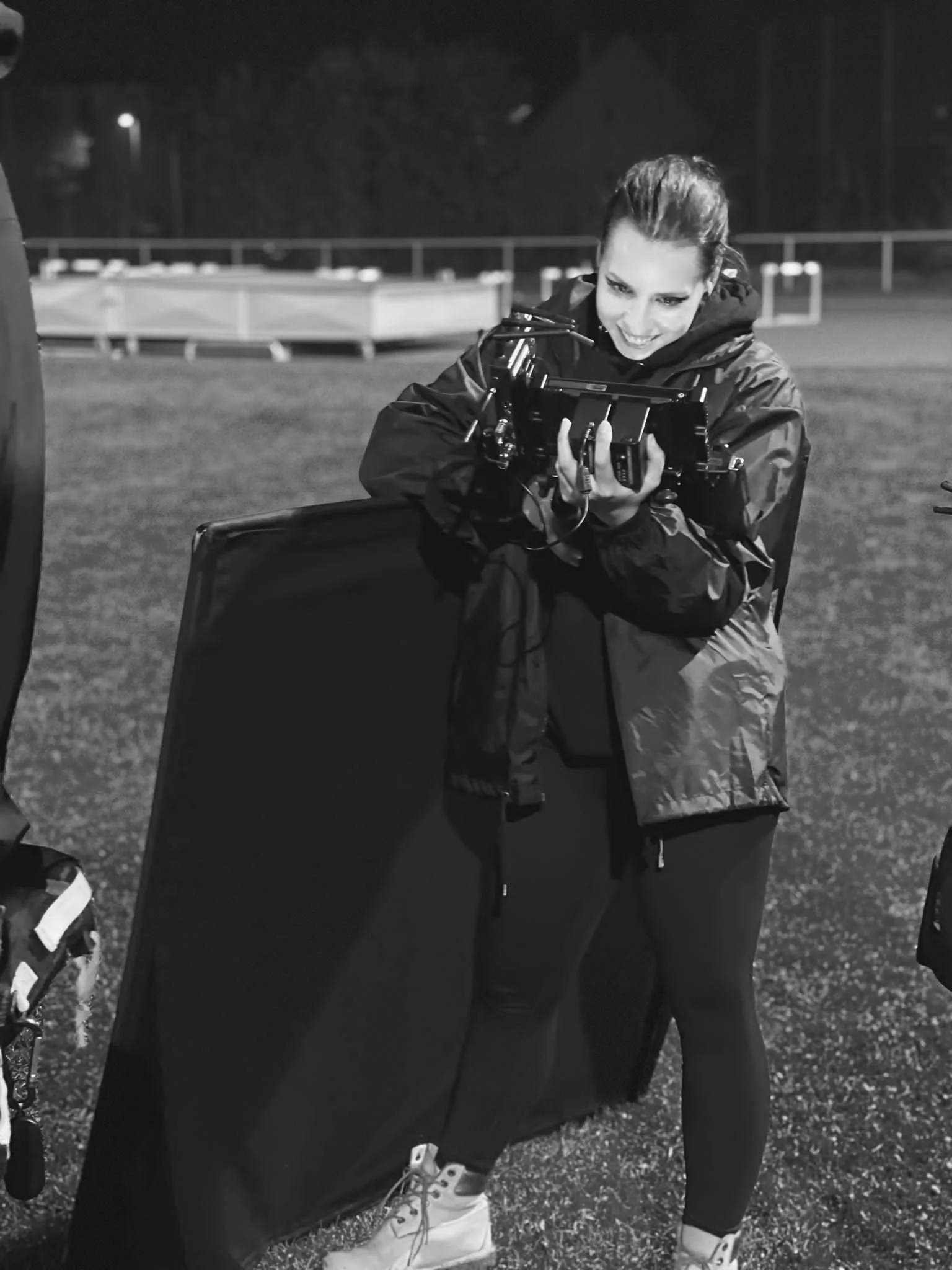 Frau die als Kameraassistentin arbeitet und lächelt