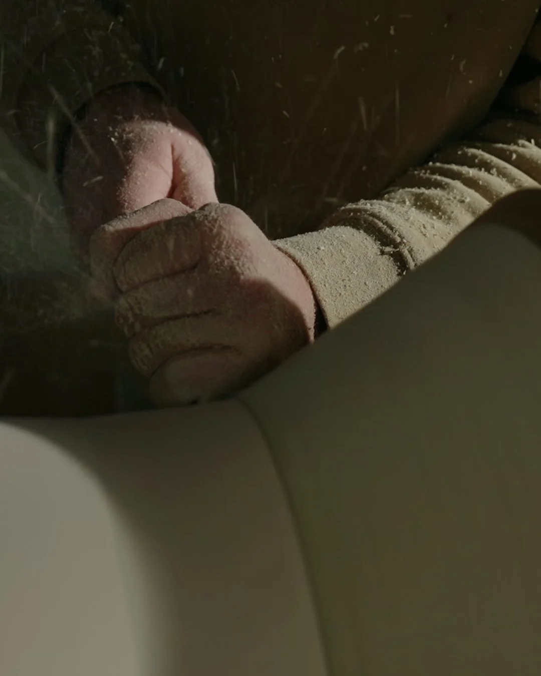 Nahaufnahme einer Hand, die ein Werkzeug beim Holzbearbeiten benutzt.