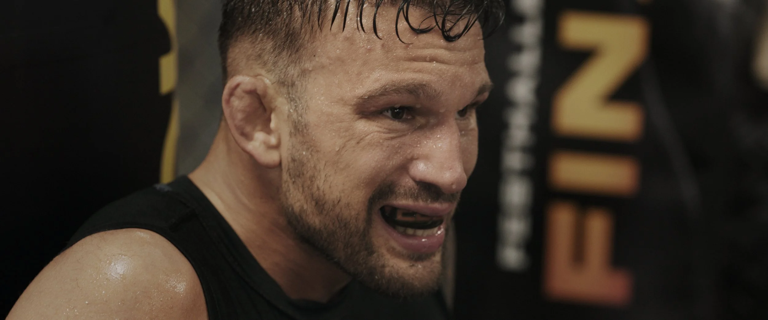 Max Coga sitzt verschwitzt auf dem Boden des MMA SpiritsSpirit Stories - Dokumentarserie - 4Reel Filmproduktion