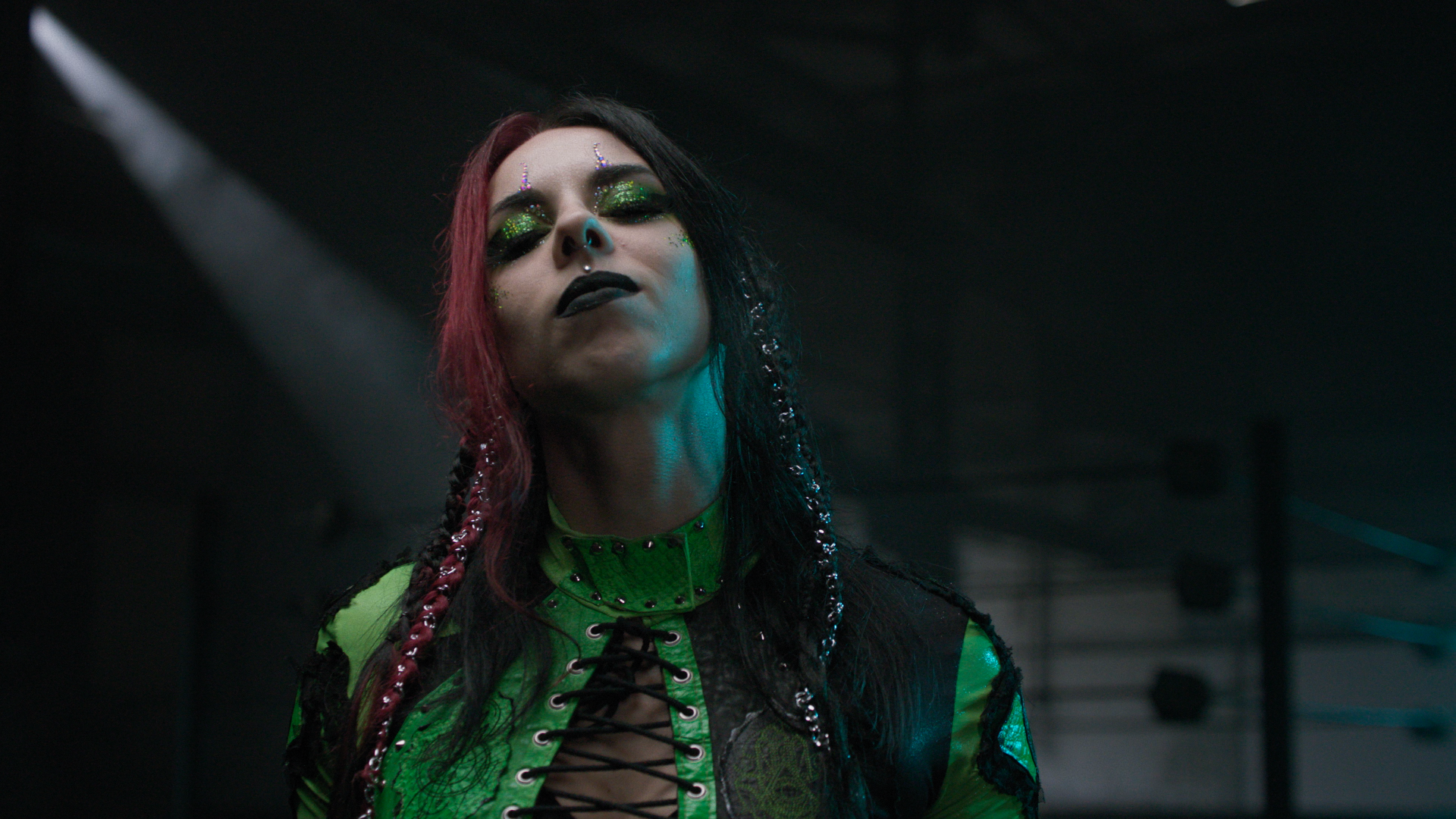 Wrestlerin Baby Allison im grün schwarzen outfit blickt in die Kamera