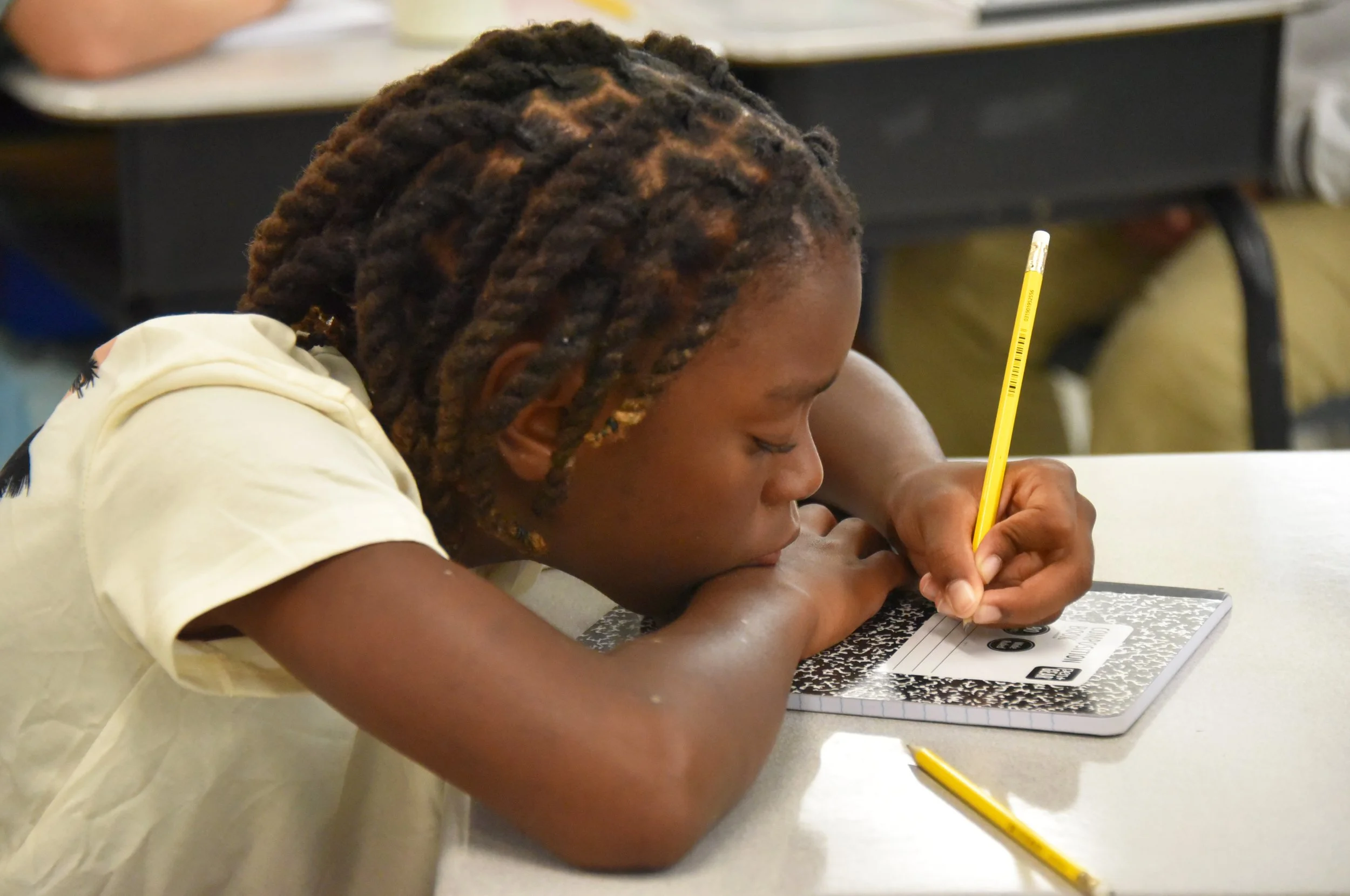 student-writing-in-notebook-classroom.jpg