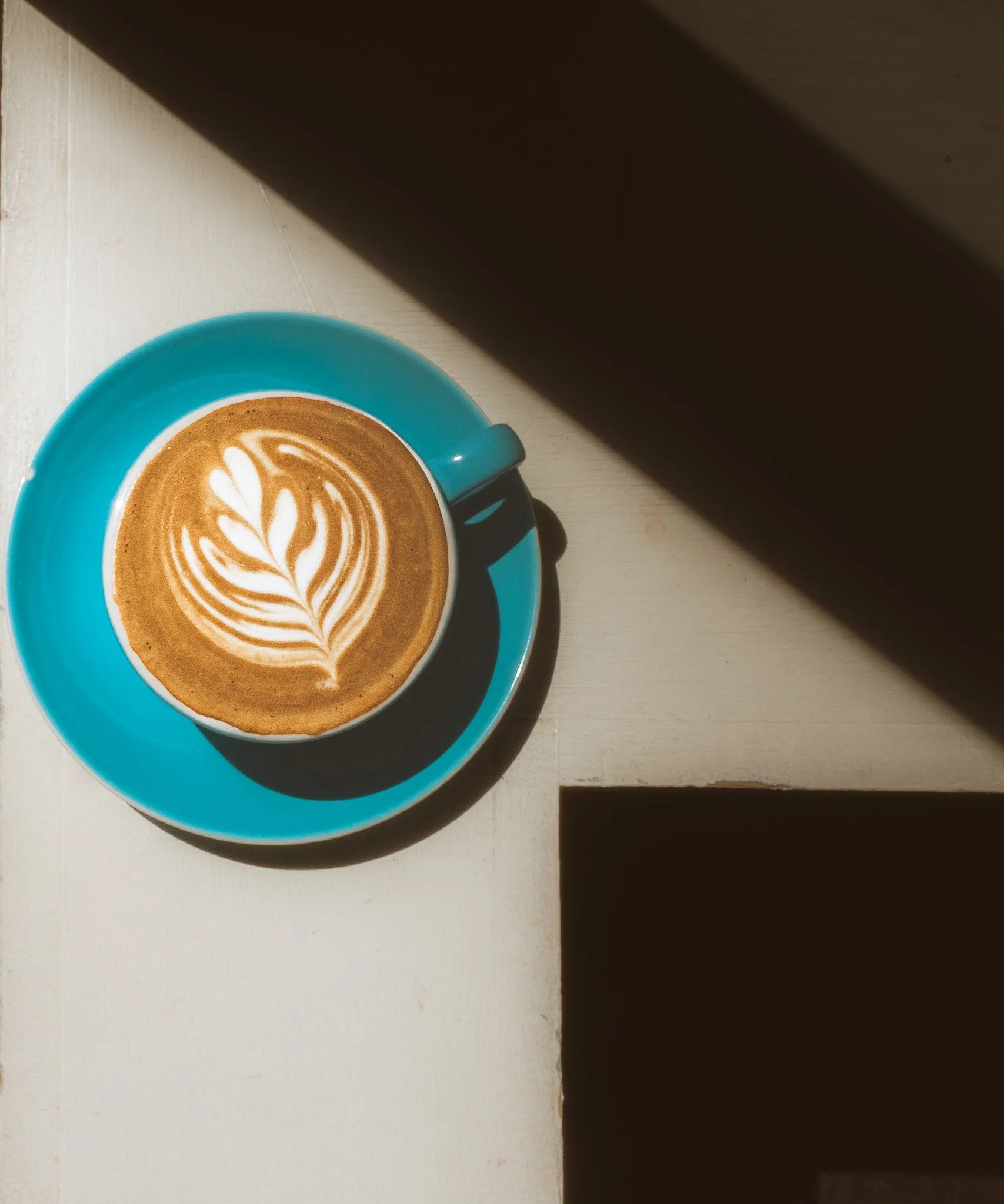 top down view of hot latte in a blue mug with beautiful flower latte art